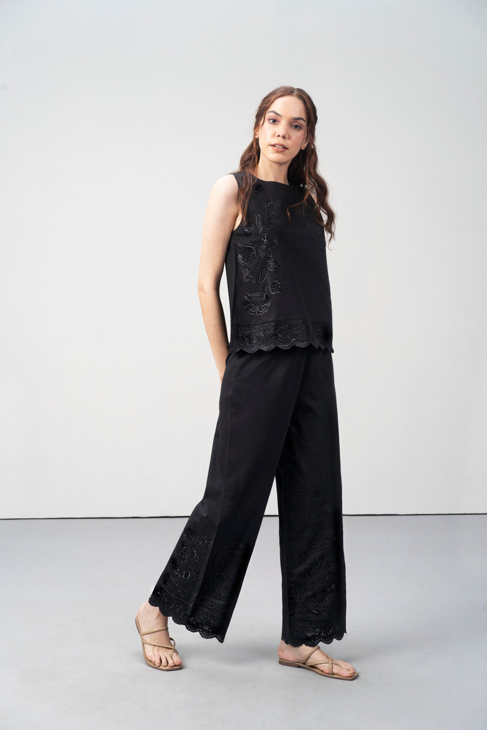 Black Embroidered Sleeveless Cotton Top For Women for Right Leg Side Model View | Cutwork Embroidery Scalloped Hem Top