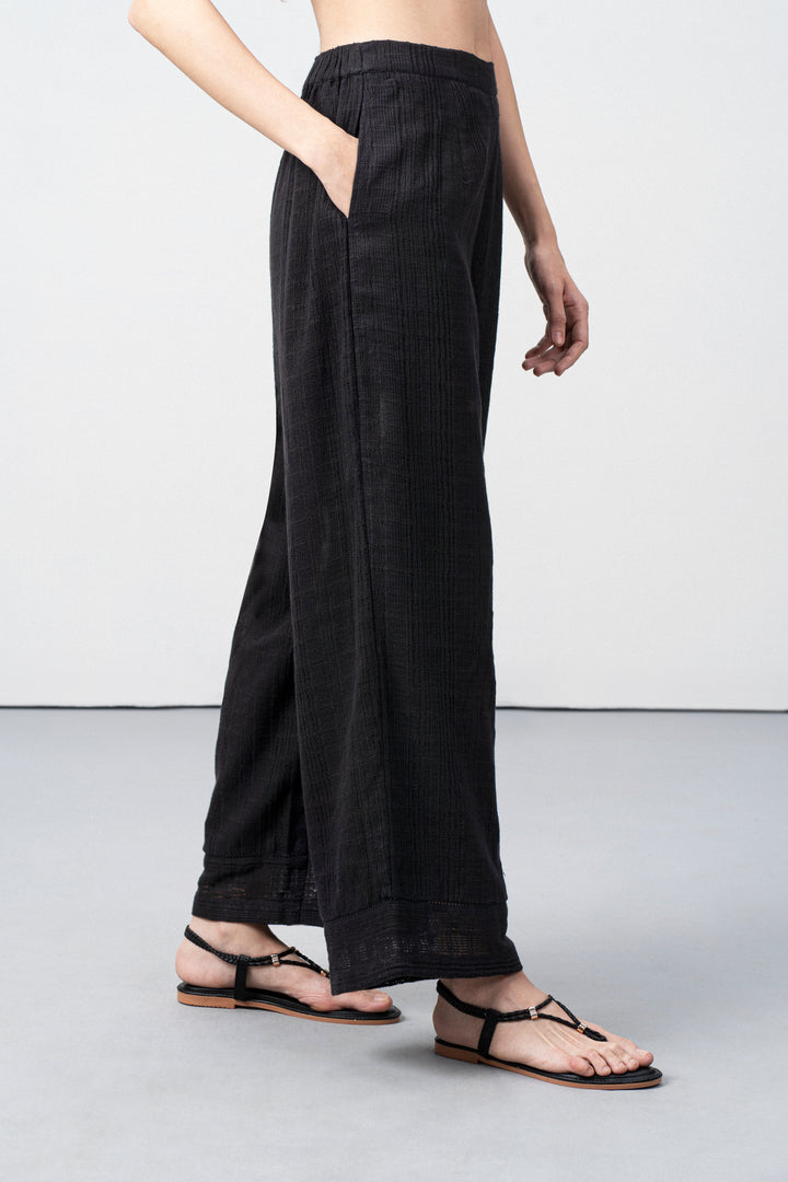 Women Pants 100% Cotton Textured Elastic Waistband Straight Fit Black Color Trousers  | Black Cotton Straight-fit Trousers For Women | Right Leg Side View Cotton Guipure Straight Fit Trousers