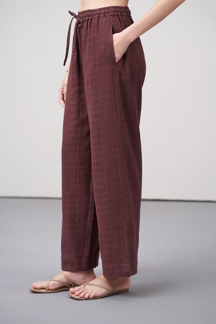 Women Pants Cotton Guipure Textured Straight Fit Elastic Waistband Maroon Trousers Left Side View | Deep Rosewood Cotton Straight-fit Trousers For Women | Cotton Guipure Elasticated Waist Trousers